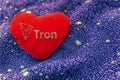 The cryptocurrency Tron symbol is a red plush heart with a neon background. TRX Royalty Free Stock Photo