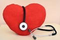 Red plush heart and stethoscope on the table Royalty Free Stock Photo