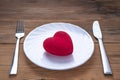 Red Plush Heart on a White Plate with Fork and Knife on Wooden Background. Minimalist Healthcare Symbol. Valentine`s Day, Romanti Royalty Free Stock Photo