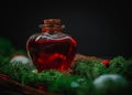 Red poison in a heart-shaped bottle lies in the bark of a tree with moss and stones on a black Royalty Free Stock Photo