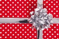 Red polka dot gift with silver bow and ribbon