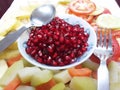 Red Pomegranate Plate of India,Red pomegranate seeds in a bowl with a spoon.