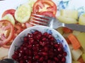 Red Pomegranate Plate of India,Red pomegranate seeds in a bowl with a spoon.