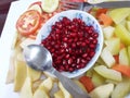 Red Pomegranate Plate of India,Red pomegranate seeds in a bowl with a spoon.