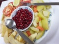 Red Pomegranate Plate of India,Red pomegranate seeds in a bowl with a spoon.