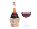Red pomegranate wine in glass and straw wine bottle Royalty Free Stock Photo