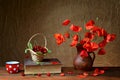 Red poppies in a ceramic vase, books,cherries and metal pots on the table Royalty Free Stock Photo