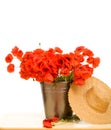 Red poppy flowers in metallic bucket and straw hat Royalty Free Stock Photo