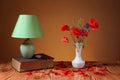 Red poppy in a vase and table lamp Royalty Free Stock Photo