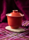 Red porcelain gaiwan on a stone