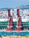 Red port cranes at industrial dock, cityscape in background Royalty Free Stock Photo