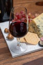 Red porto and cheese pairing, blue matured stilton English cheese served as dessert with walnuts and glass ruby porto wine