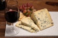 Red porto and cheese pairing, blue matured stilton English cheese served as dessert with walnuts and glass ruby porto wine