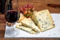 Red porto and cheese pairing, blue matured stilton English cheese served as dessert with walnuts and glass ruby porto wine