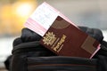 Red Portugal passport of European Union with airline tickets on touristic backpack