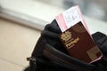 Red Portugal passport of European Union with airline tickets on touristic backpack