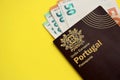 Red Portugal passport of European Union and money on yellow background close up