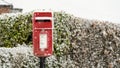 A Red post box at Christmas covered with falling snow Royalty Free Stock Photo