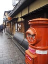 Red post box standing alone in the rainy days in Kyoto street