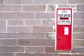 Red post letter box vintage retro in stone wall rural countryside village Royalty Free Stock Photo