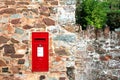 Red postbox in stone wall Royalty Free Stock Photo