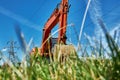 A red powerful crawler excavator standing on the grass. Rent, rent for earthworks. Summer sunny morning