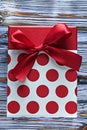 Red present box with ribbon on vintage wooden board Royalty Free Stock Photo