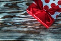 Red present box with ribbon on vintage wooden board Royalty Free Stock Photo