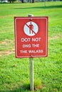 Red prohibition sign with text Do Not Ding The Walass in a grassy park image photo Royalty Free Stock Photo