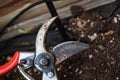 Red pruning shears closeup with the soil on the background - Image Royalty Free Stock Photo