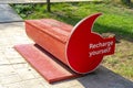 red public garden bench with suggestion to recharge your energies.