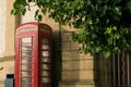 Red public phone box in front of a wall in Britain Royalty Free Stock Photo