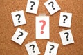 Red question mark on a piece of paper and many question marks on cork board. Royalty Free Stock Photo