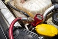 A red quick-release coupler is installed on the valve from the air conditioning system in the car to fill the R134a refrigerant. Royalty Free Stock Photo
