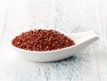 Red quinoa in white porcelain spoon