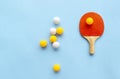Red racket for table tennis with yellow white balls on blue background. Ping pong sports equipment in minimal style. Flat lay, top Royalty Free Stock Photo