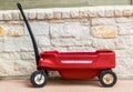 Red Radio Flyer wagon against a stone wall