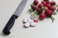 red radishes on wooden cutting board, and table