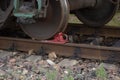 Red rail shoe under the wheel of the carriage on the rails Royalty Free Stock Photo