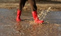 Red rain boots in puddle Royalty Free Stock Photo