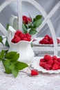 Red raspberries, green leaves, and white lace in a shabby chic background. Royalty Free Stock Photo