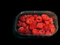 Red raspberries in plastic package isolated on black background Royalty Free Stock Photo