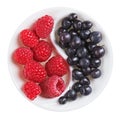 Red raspberry versus black bilberry in plate Royalty Free Stock Photo