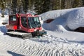 Red ratrak snowcat in winter mountains A red snow tucker covered with snow in Krkonose mountain. Red over-snow vehicle, Royalty Free Stock Photo