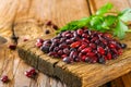 Red raw beans with greens on a wooden table. Royalty Free Stock Photo