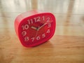 Red rectangle alarm clock on wooden table Royalty Free Stock Photo