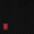 Red rectangle rocker power switch in on position, black abstract dot texture frame vertical pattern, natural blank empty copy