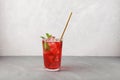 Red refreshing drink with mint on grey background. Colorful summer non-alcoholic refreshing drink with ice, fruit iced tea Royalty Free Stock Photo