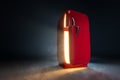 Red refrigerator retro fridge with opened doors emit steam and bright warm white light in dark empty room Royalty Free Stock Photo