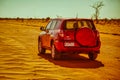 Red rental car on durt road Royalty Free Stock Photo